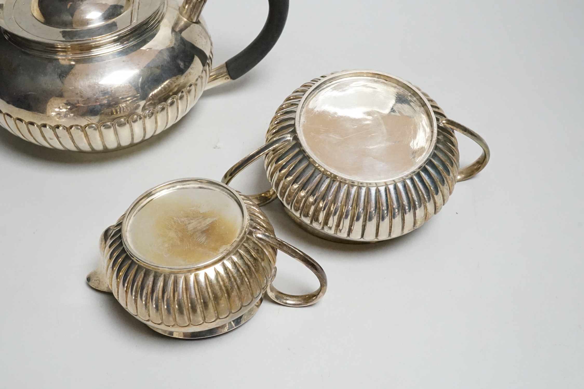 A late Victorian demi-fluted silver three piece tea set, by Hukin & Heath, 1893/4/5, gross weight 27.6oz.